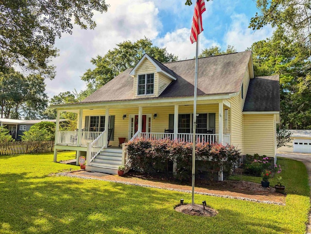 view of front of house featuring a garage, covered porch, and a front yard