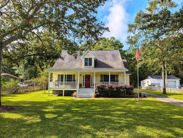 cape cod house with a garage, an outdoor structure, covered porch, and a front yard