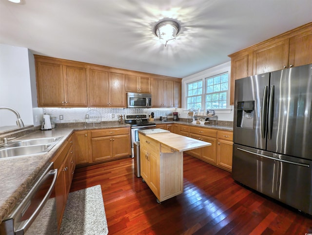 kitchen featuring butcher block countertops, tasteful backsplash, dark wood-type flooring, stainless steel appliances, and sink