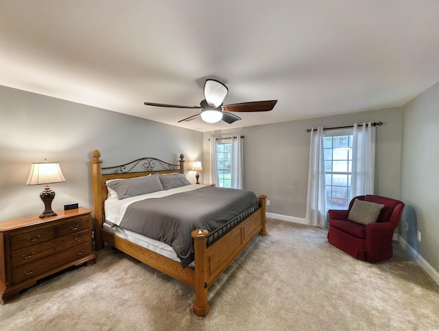 bedroom featuring multiple windows, ceiling fan, and light colored carpet