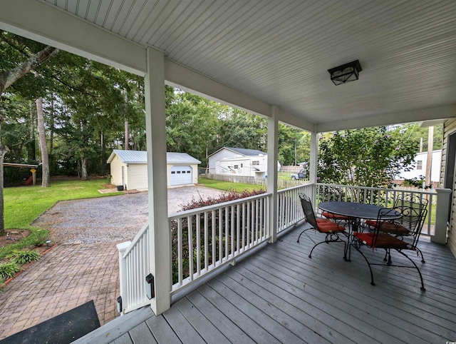 wooden deck with an outdoor structure, a garage, and a yard