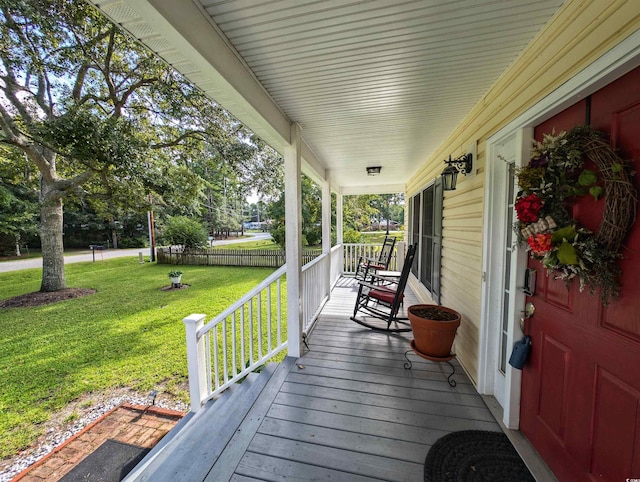 wooden deck featuring a lawn