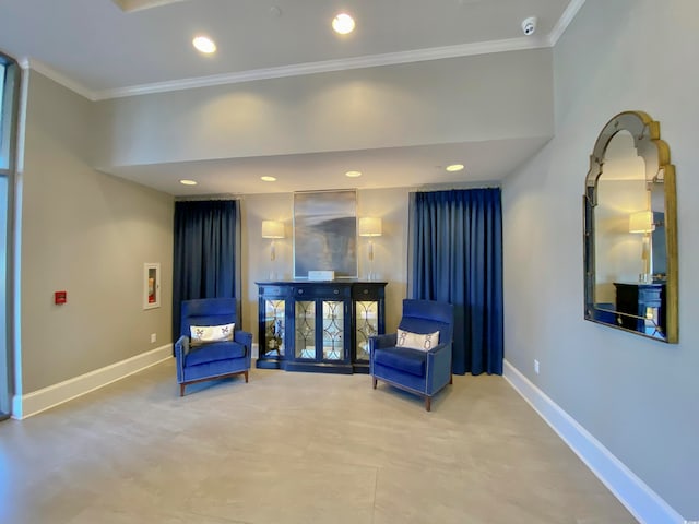 sitting room with ornamental molding and tile patterned floors