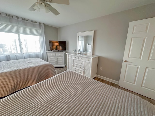 bedroom featuring baseboards, ceiling fan, and wood finished floors