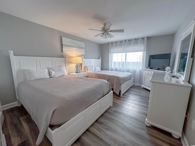 bedroom featuring baseboards, wood finished floors, and ceiling fan