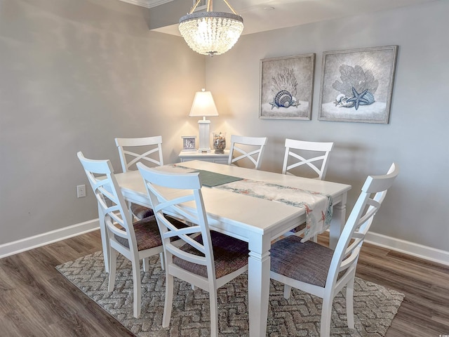 dining space with dark wood-type flooring and a chandelier