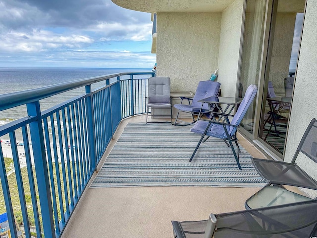 balcony featuring a water view and a view of the beach
