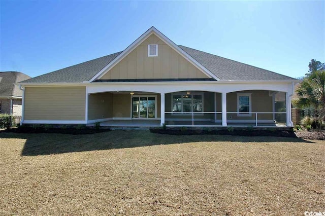 view of front facade with a sunroom and a front lawn