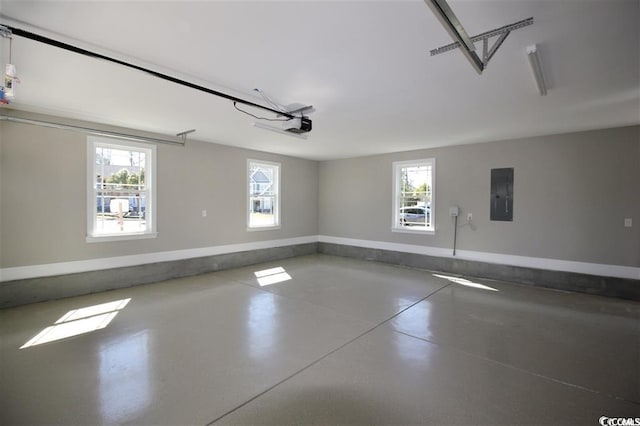 spare room featuring a wealth of natural light, concrete floors, and electric panel