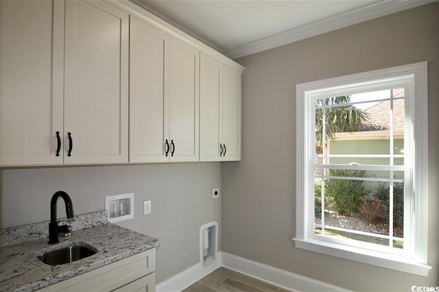 clothes washing area featuring plenty of natural light, hookup for an electric dryer, cabinets, and sink