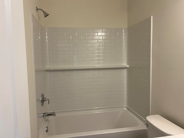 bathroom featuring tiled shower / bath and toilet