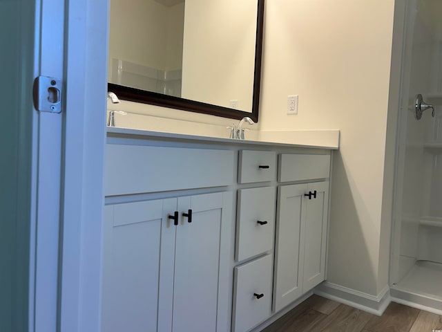 bathroom with a shower, vanity, and hardwood / wood-style flooring