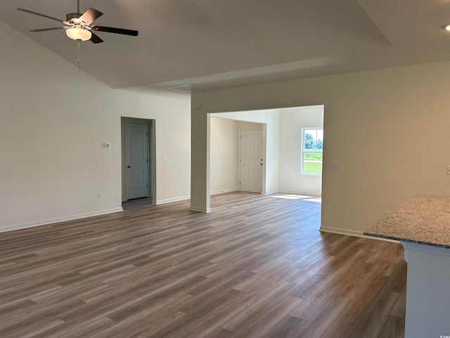 spare room with ceiling fan, vaulted ceiling, and dark hardwood / wood-style flooring