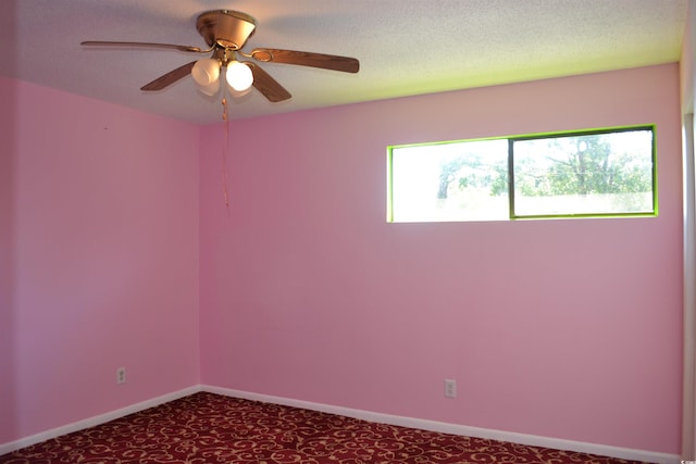 empty room featuring a textured ceiling, carpet flooring, and ceiling fan