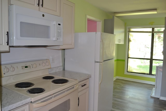 kitchen featuring light stone counters, white cabinets, light hardwood / wood-style floors, and white appliances