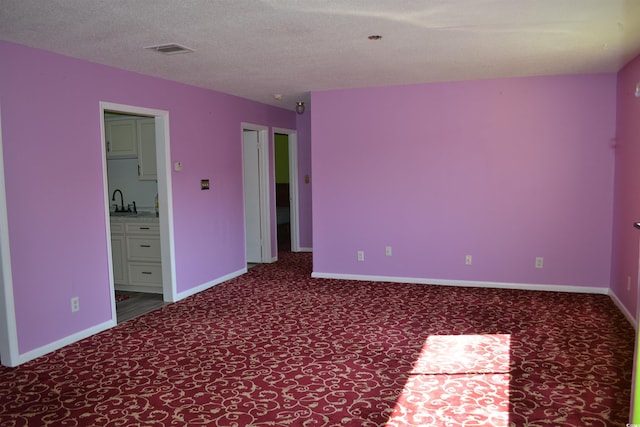 unfurnished room featuring a textured ceiling and sink