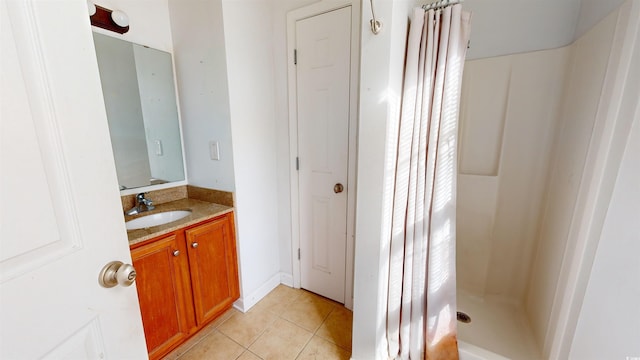 bathroom with walk in shower, vanity, and tile patterned flooring