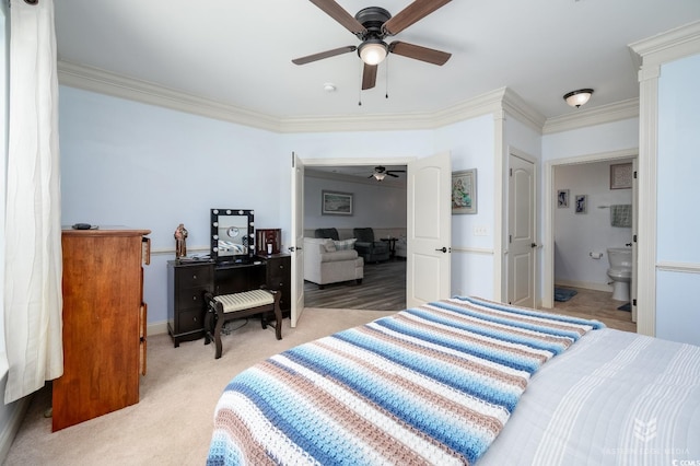 bedroom with ensuite bath, light colored carpet, ornamental molding, and ceiling fan