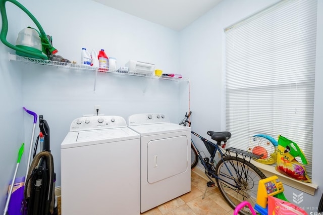 laundry room with washer and clothes dryer and light tile patterned floors