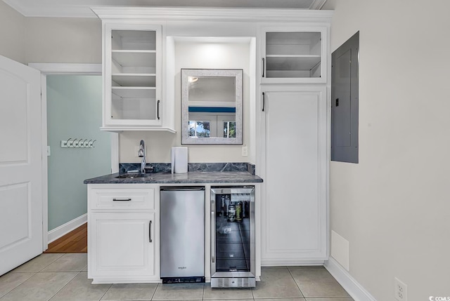 kitchen with wine cooler, stainless steel fridge, light tile patterned floors, electric panel, and white cabinetry