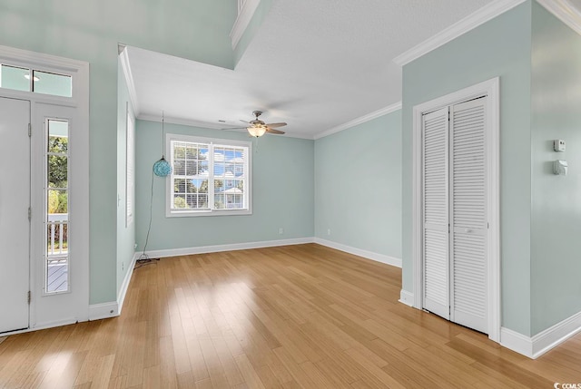 foyer featuring crown molding, ceiling fan, plenty of natural light, and light wood-type flooring