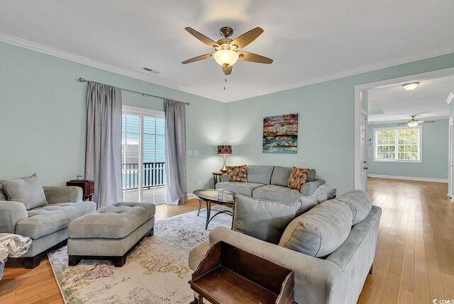 living room featuring crown molding, light hardwood / wood-style floors, and ceiling fan