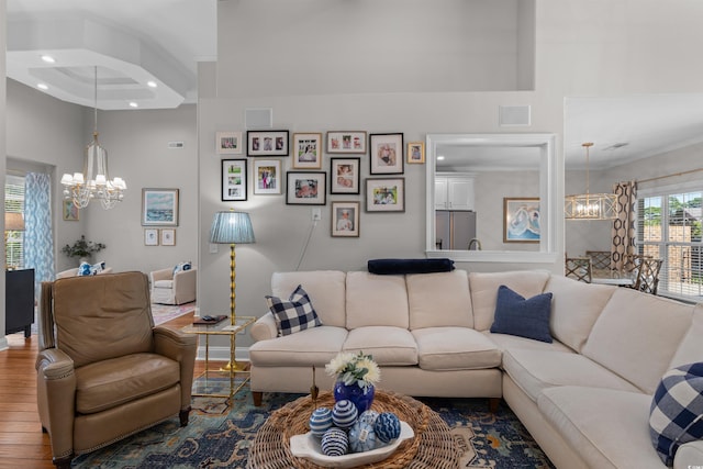 living area with a chandelier, wood finished floors, visible vents, and recessed lighting