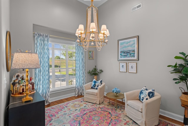 sitting room featuring visible vents, baseboards, a chandelier, and wood finished floors