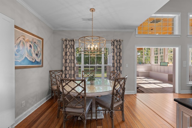 dining area featuring crown molding, baseboards, a notable chandelier, and hardwood / wood-style flooring