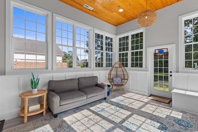 sunroom / solarium featuring wood ceiling and plenty of natural light