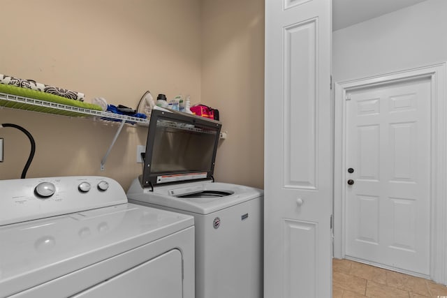 laundry room featuring light tile patterned flooring and washing machine and dryer