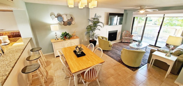 living room with light tile patterned flooring, ceiling fan, and a fireplace