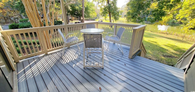 wooden terrace featuring a water view and a yard