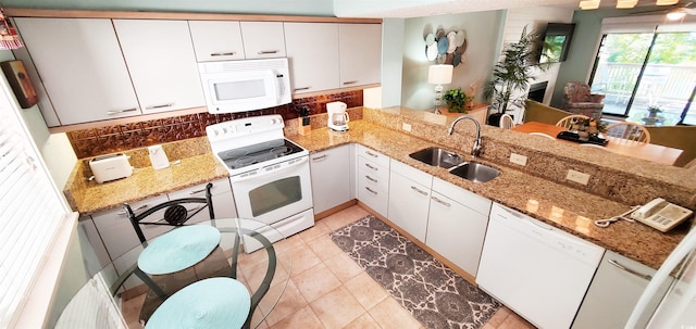 kitchen with white cabinetry, kitchen peninsula, sink, and white appliances