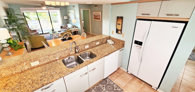 kitchen featuring white cabinetry, light stone countertops, sink, and white refrigerator with ice dispenser