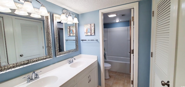 full bathroom featuring toilet, tile patterned flooring, a textured ceiling, vanity, and shower / tub combination