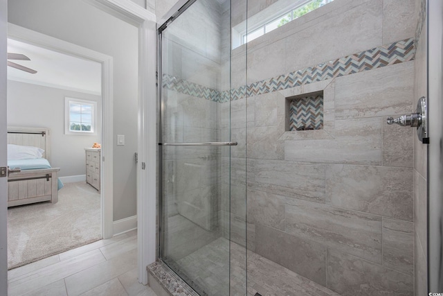 bathroom with crown molding, a shower with door, ceiling fan, and tile patterned flooring