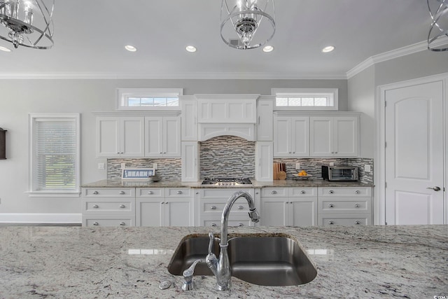 kitchen featuring a healthy amount of sunlight, decorative backsplash, and sink