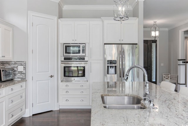 kitchen featuring dark wood-type flooring, stainless steel appliances, sink, white cabinetry, and light stone counters