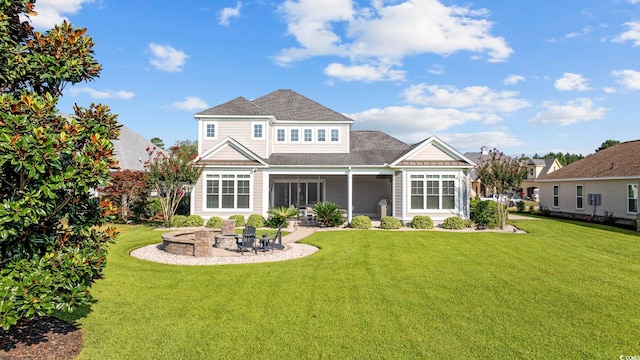 back of property featuring a fire pit, a patio area, a sunroom, and a lawn