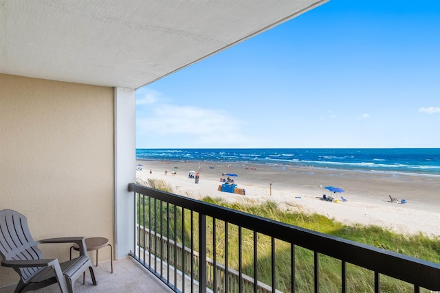 balcony featuring a view of the beach and a water view