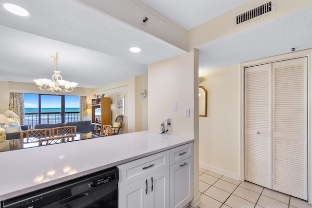 kitchen featuring light tile patterned flooring, white cabinets, black dishwasher, decorative light fixtures, and a notable chandelier