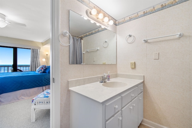 bathroom featuring walk in shower, vanity, and ceiling fan