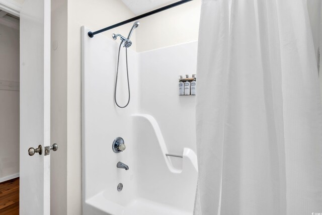 bathroom featuring shower / bath combo and wood-type flooring