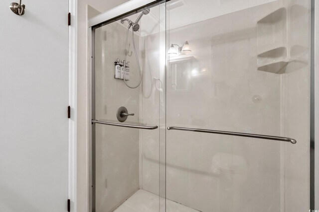 bathroom with a shower with door