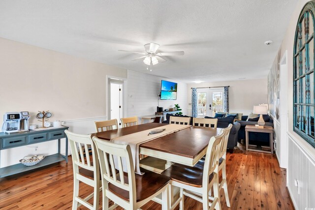 dining room with dark wood-type flooring, ceiling fan, a textured ceiling, and french doors