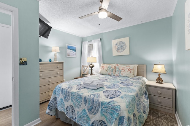 bedroom featuring light wood-type flooring, ceiling fan, crown molding, and a textured ceiling