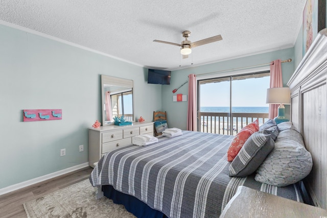 bedroom featuring light wood-type flooring, a textured ceiling, access to outside, ornamental molding, and ceiling fan