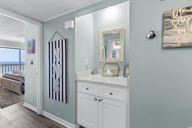 bathroom featuring vanity, wood-type flooring, a textured ceiling, and a water view