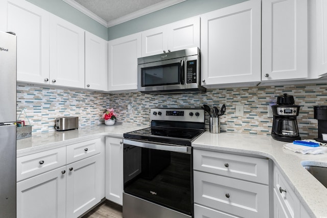 kitchen with appliances with stainless steel finishes, decorative backsplash, light stone counters, and white cabinets